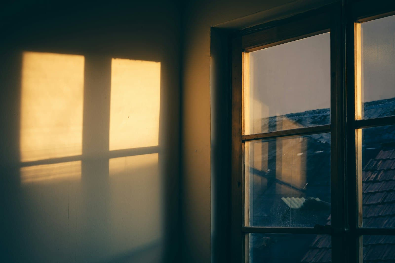 Low sun shining through the windows of a house onto a wall